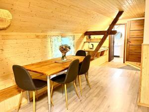 a wooden dining room with a wooden table and chairs at Na Mlejně in Krahulčí