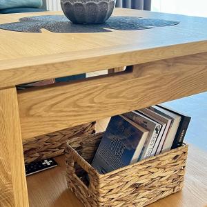 a table with a basket of books underneath it at Apartament SOLMARINA in Iława