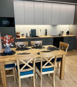 a kitchen with a wooden table and chairs at Apartament SOLMARINA in Iława