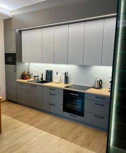 a kitchen with white cabinets and a stove top oven at Apartament SOLMARINA in Iława