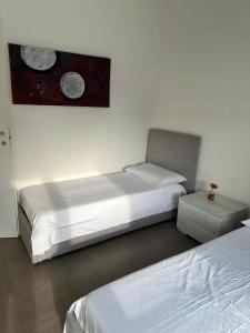 a bedroom with two beds and a painting on the wall at La Siesta in Seregno