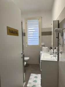 a white bathroom with a toilet and a sink at La Siesta in Seregno +22 photos