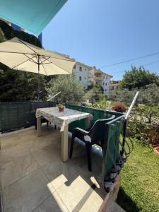 a table and chair with an umbrella on a patio at Sahil Apart in Datca