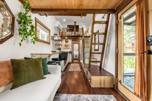 a tiny house with a staircase and a living room at The Fern Hollow Retreat in Woodland Park