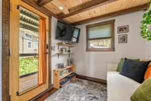 a living room with a couch and a tv and a window at The Fern Hollow Retreat in Woodland Park