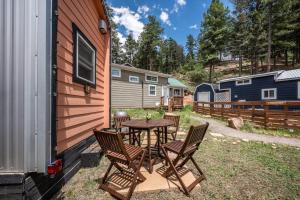 a patio with a table and chairs next to a house at The Fern Hollow Retreat in Woodland Park