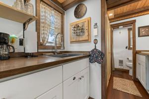 a kitchen with a sink and a clock on the wall at The Fern Hollow Retreat in Woodland Park +27 photos