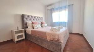 a bedroom with a large bed and a window at albufeira sweety house in Albufeira