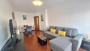 a living room with a blue couch and yellow pillows at albufeira sweety house in Albufeira