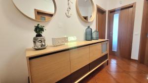 a dresser in a hallway with two mirrors at albufeira sweety house in Albufeira +23 photos