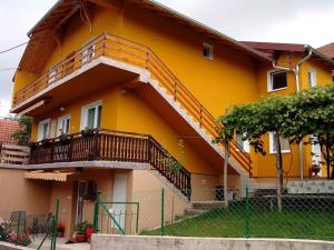 a yellow house with a staircase on the side of it at Vila Zlata in Gornja Trepča