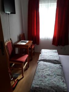 a bedroom with a bed and a table and a window at Vila Zlata in Gornja Trepča +2 photos