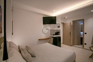 a white bedroom with a bed and a kitchen at Mykonos Windmills View in Megali Ammos