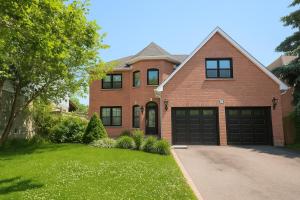 a brown brick house with a garage at Luxury home 4BR, Pool, & 5 Mins to 401 in Whitby