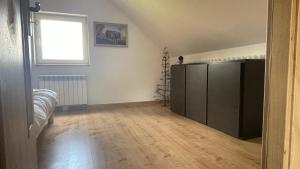 een lege woonkamer met een grote zwarte kast bij Domek w Limanowej in Limanowa