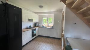 a small kitchen with white cabinets and a window at Domek w Limanowej in Limanowa