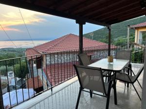 a patio with a table and chairs on a balcony at Soleil House in Kallirakhi