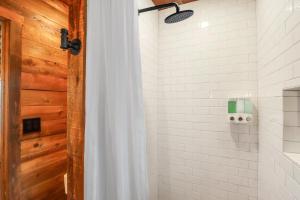 La salle de bains est pourvue d'une douche et d'un mur en bois. dans l'établissement RusTx Ranch Unit 3- Colorado, à Wimberley 10 autres photos