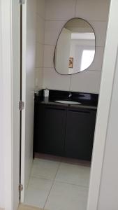 a bathroom with a sink and a mirror at Studio Cinema 75 & Garage in Caxias do Sul