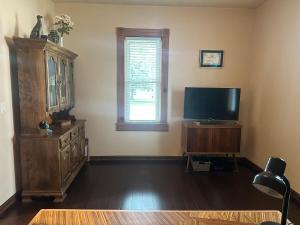 a living room with a television and a dresser at Charming Brick House in Little Chute