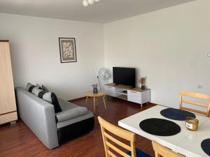 a living room with a couch and a table at A MORZE TUTAJ - apartament z dużym tarasem in Stegna