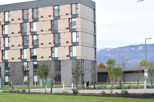 a man standing in front of a building at Residence & Conference Centre - Kelowna in Kelowna