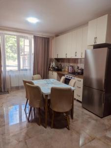 a kitchen with a table with chairs and a refrigerator at OR-Ni in Borjomi +34 photos