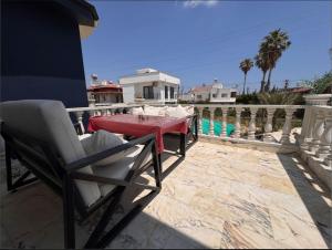 a patio with a table and a chair on a balcony at EVA Palmera in Silifke