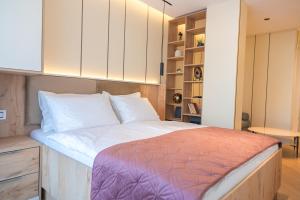 a bedroom with a large bed with white cabinets at Guesthouse Sidro in Ulcinj