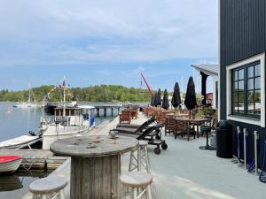 Un muelle con una mesa y sillas y barcos en el agua. en 4 star holiday home in VÄDDÖ, en Väddö 20 fotos más