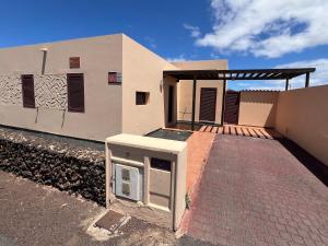 ein Haus mit einer gepflasterten Auffahrt davor in der Unterkunft Anahi Homes Corralejo - Villa Dracaena 2 in La Oliva