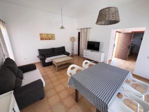 ein Wohnzimmer mit einer Couch und einem Tisch in der Unterkunft Anahi Homes Corralejo - Villa Dracaena 2 in La Oliva
