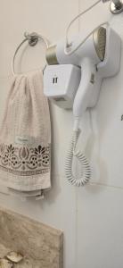 a white hair dryer hanging on a wall in a bathroom at casa temporada lua nova centro in Alto Paraíso de Goiás +26 photos