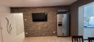 a kitchen with a television on a brick wall at Exclusiv new family in Năvodari