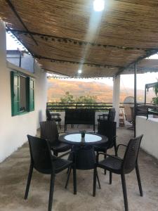 un patio con tavolo e sedie con vista di Ehden's Skyline a Ehden