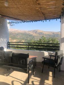 veranda con divano, tavolo e vista di Ehden's Skyline a Ehden