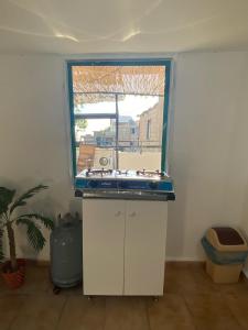 una cucina con piano cottura in una camera con finestra di Ehden's Skyline a Ehden