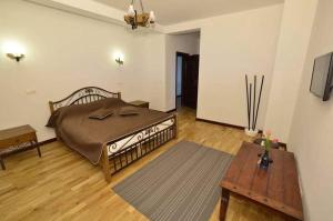 a bedroom with a large bed and a table at Eden in Piatra Fantanele