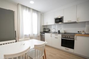 a kitchen with white cabinets and a white counter top at LETS HOLIDAYS Wake Up by the Sea in Victoria apartment 2 in Tossa de Mar