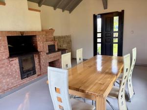a dining room with a wooden table and a fireplace at Eden in Piatra Fantanele
