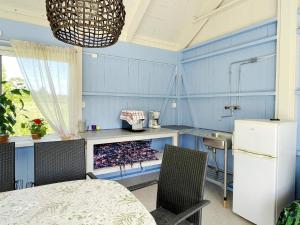 a kitchen with blue walls and a table and chairs at Charming Garden Cottage in Levide in Hemse