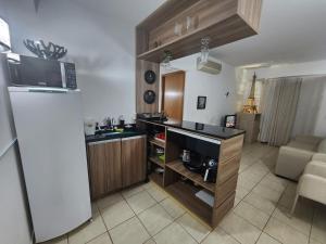 a kitchen with a refrigerator and a counter top at Apartamento Giardino Rio Quente in Rio Quente
