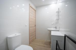 a white bathroom with a toilet and a sink at LETS HOLIDAYS Wake Up by the Sea in Victoria apartment 2 in Tossa de Mar +40 photos