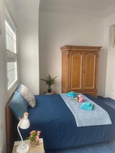 a bedroom with a blue bed and a wooden cabinet at Vivienda Vacacional La Pepita in Santa Cruz de la Palma