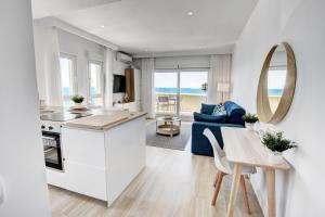 a kitchen and a living room with a table at Beachfront Parque Paloma in Benalmádena