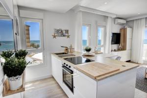 a kitchen with a sink and a counter with windows at Beachfront Parque Paloma in Benalmádena