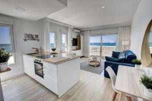 a kitchen and living room with a blue couch at Beachfront Parque Paloma in Benalmádena