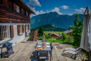 a table on a patio with a view of mountains at Chalet 6 personnes avec sauna in Leysin