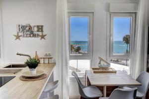 a beach house with a dining room with a table and chairs at Beachfront Parque Paloma in Benalmádena +30 photos