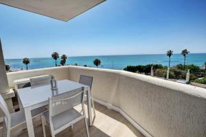 a balcony with a table and chairs and the ocean at Beachfront Parque Paloma in Benalmádena